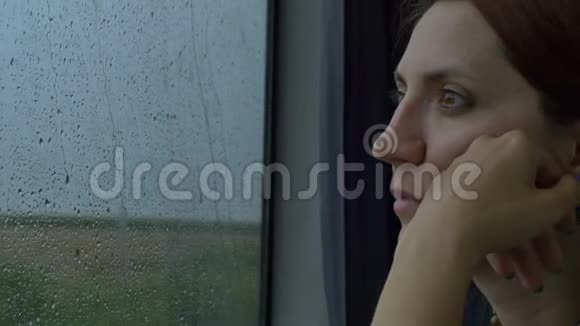 女人看着下雨的火车窗口视频的预览图