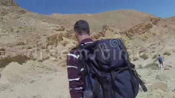在岩石沙漠的徒步旅行者视频的预览图