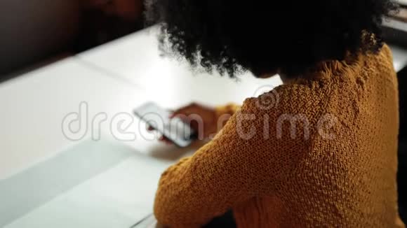 在咖啡馆里用智能手机的非洲女人视频的预览图