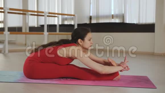 在工作室做瑜伽运动的女人适合运动女孩坐在垫子上伸展练习体式姿势和视频的预览图