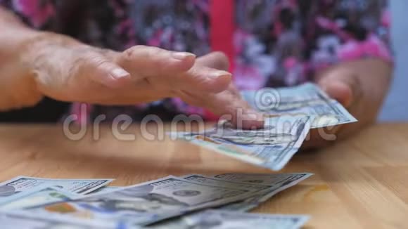 祖母手里拿着一捆钱把外币撒在桌子上一只老女人扔的胳膊视频的预览图
