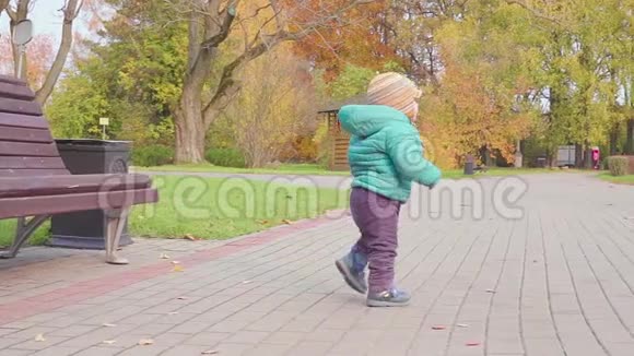 有趣的微笑一岁的男孩走在公园的日落手里拿着面包快乐的童年概念慢动作视频的预览图