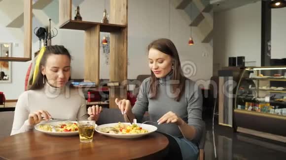 两个女朋友在咖啡馆里一起吃饭聊天享受他们的食物视频的预览图