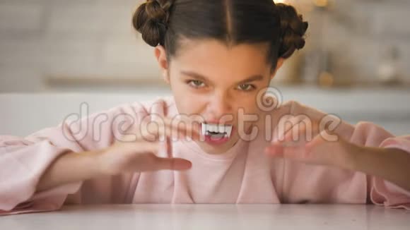 在万圣节前夜的派对上一个长着大尖牙的小吸血鬼女孩做着恐怖的脸视频的预览图