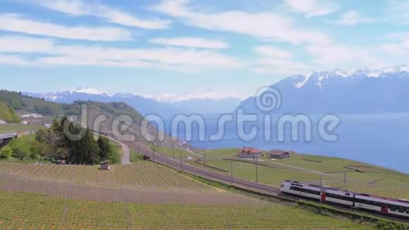 瑞士火车沿着位于日内瓦湖附近山坡上的一条风景优美的铁路与阿尔卑斯山相对行驶瑞士视频的预览图