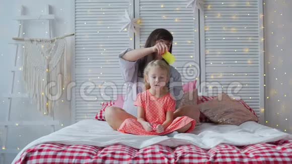 妈妈在床上给女儿们梳头视频的预览图