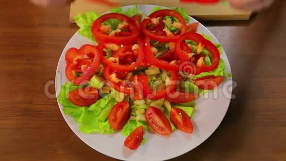 女用手把红椒圈放在盘子里里面放着生菜和西红柿视频的预览图