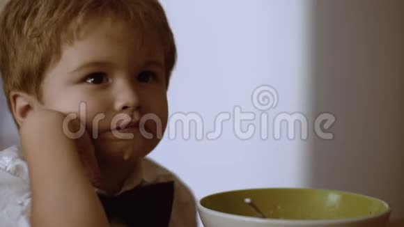 可爱的小孩看动画片吃牛奶粥视频的预览图