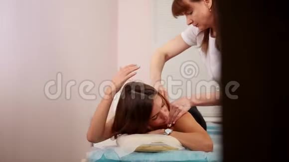 美容诊所一位年轻的黑发女人正在接受放松的背部按摩视频的预览图