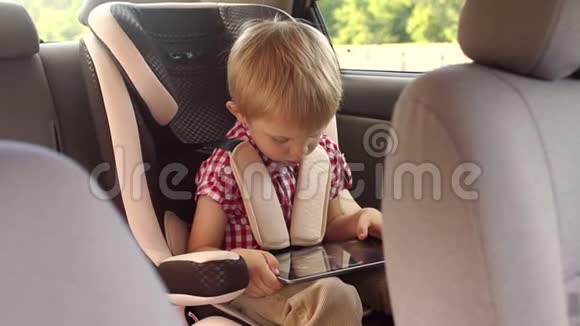 带平板电脑的汽车座椅上的小孩肖像视频的预览图