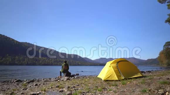 山湖堕落黄色帐篷那个女人带着西利特背包在湖边的旅行者视频的预览图