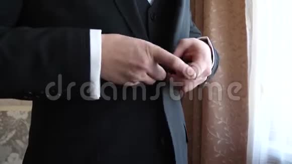 男人的手扣在一套黑色的三件西装上特写视频的预览图