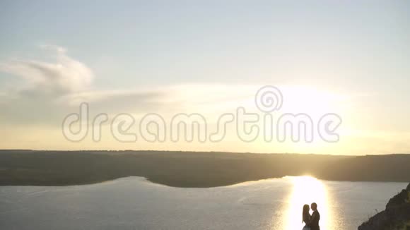 新娘站在一个大湖的岸边视频的预览图