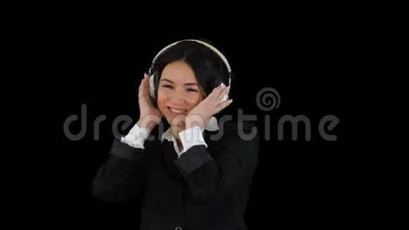 年轻的商务女性听着耳机音乐和跳舞阿尔法频道视频的预览图