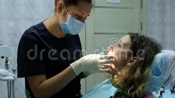 牙医正畸医生为一名妇女安装一个支架系统放置一个牙科固定器去看牙医视频的预览图