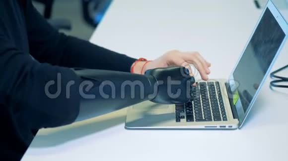 一个有机器人机械臂概念的人正在电脑上打字视频的预览图