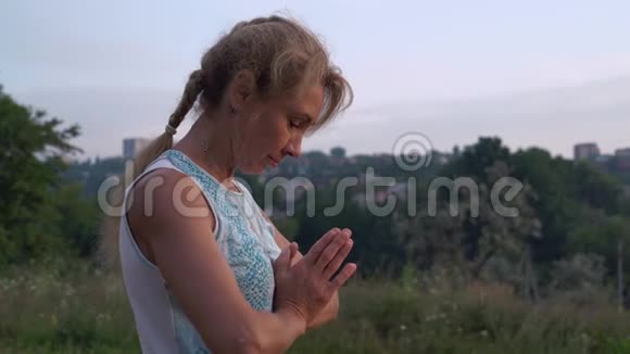 女Yogin看着太阳升起的一面手牵手在Namaste欢迎来到城市公园视频的预览图