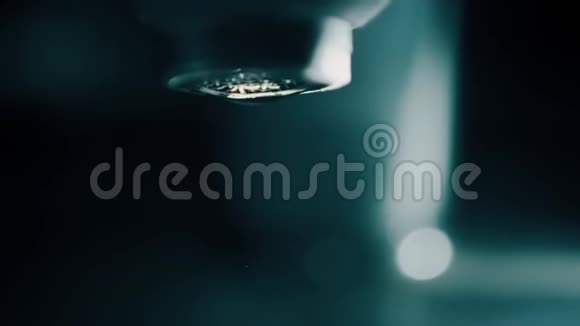 在黑暗的浴室里从水龙头上落下的慢镜头视频的预览图