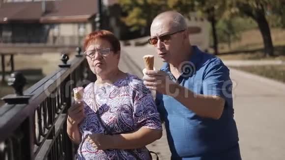 一对年长的夫妇带着冰淇淋走在长廊上聊天视频的预览图