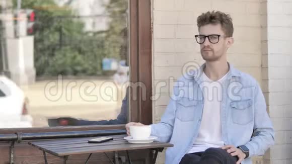 户外坐着的年轻人喝咖啡视频的预览图