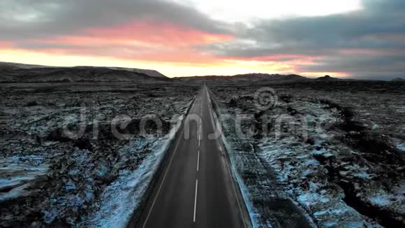 冰岛的道路被覆盖着雪空中的熔岩田所包围视频的预览图