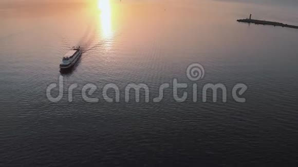 跟随白船游艇空中日落顶部灯塔景观与船在背景温暖的夕阳景观视频的预览图