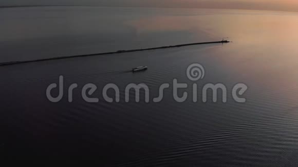跟随白船游艇空中日落顶部灯塔景观与船在背景温暖的夕阳景观视频的预览图