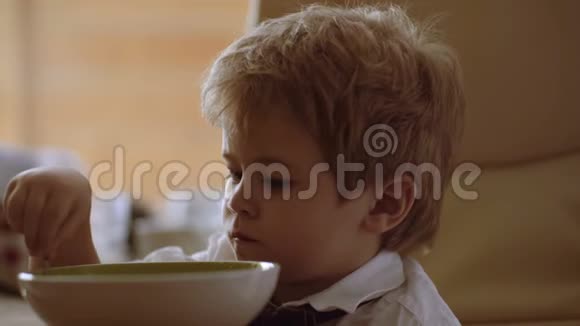 孩子看动画片小孩子在喝粥有趣的男孩吃牛奶粥视频的预览图