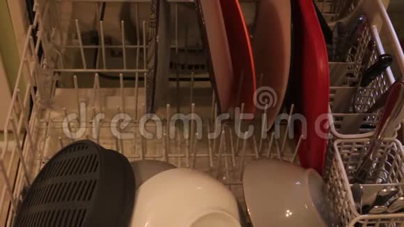 女人倒洗碗机女人在做家务女人从洗碗机里拿盘子干净的餐具视频的预览图