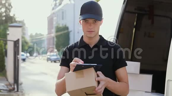 送货服务手拿盒子的快递公司靠近停车场视频的预览图