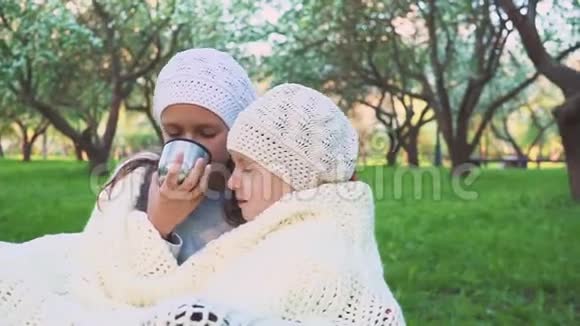两个女孩在公园里喝茶很热特写镜头视频的预览图