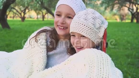 两个可爱的小妹妹在美丽的春天拥抱和拥抱户外家庭纽带开心地笑视频的预览图