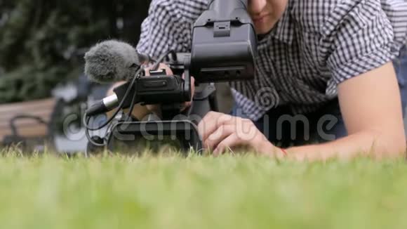 躺在草地上的摄影师正在拍摄视频的预览图