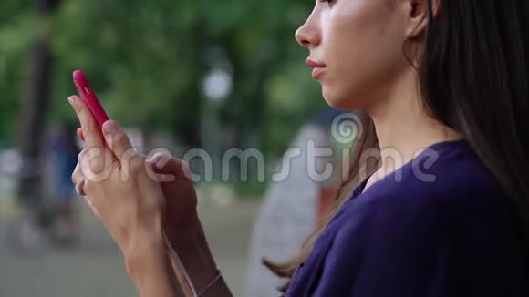 女人坐在长凳上用智能手机近景视频的预览图