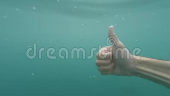 男手显示情人节心牌手势水下蓝色带泡泡手势和手势肢体语言视频的预览图