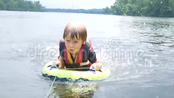 男孩漂浮在河里救生衣在行动中视频的预览图