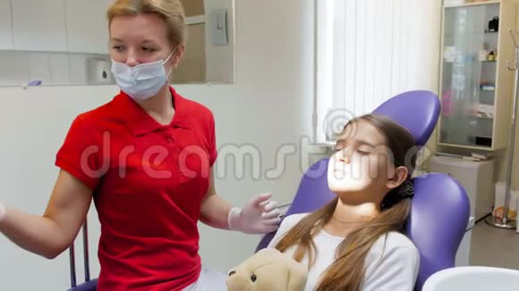 4k片女性牙科医生从青少年牙齿中取出龋齿镜头视频的预览图
