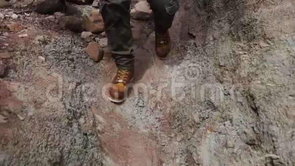 走在岩石小径上的年轻徒步旅行者的腿部动作缓慢视频的预览图