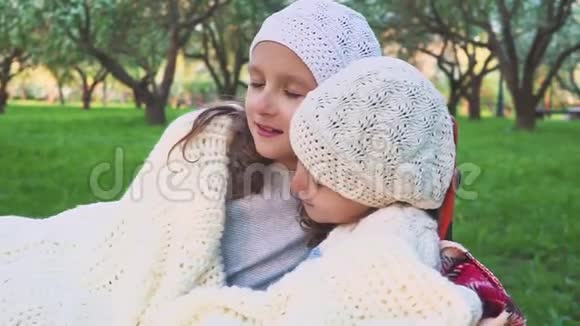 两个可爱的小妹妹在美丽的春天拥抱和拥抱户外家庭纽带他们闭着眼睛视频的预览图