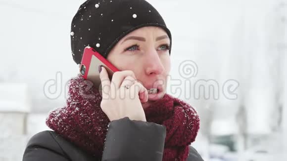 年轻女性有智能手机和冬季景观户外女孩使用移动智能手机户外下雪视频的预览图