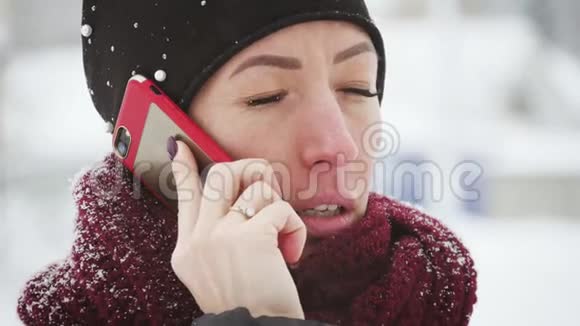 年轻女性有智能手机和冬季景观户外女孩使用移动智能手机户外下雪视频的预览图