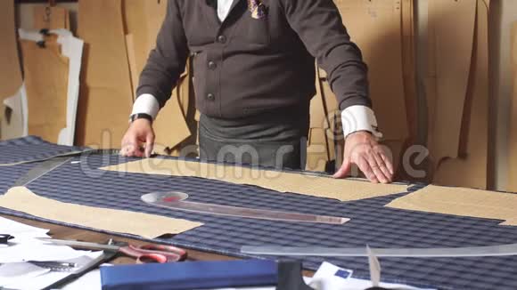 成熟的专业裁缝与测量棒准备织物的服装制作视频的预览图