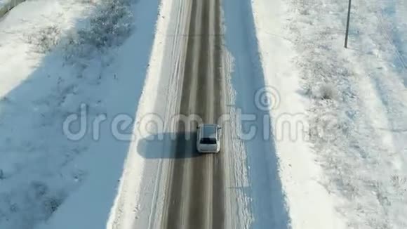 在白雪皑皑的森林里骑着车鸟瞰雪林松树高路上有车视频的预览图