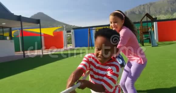 在学校操场玩拔河游戏的混血学童的正面景色视频的预览图