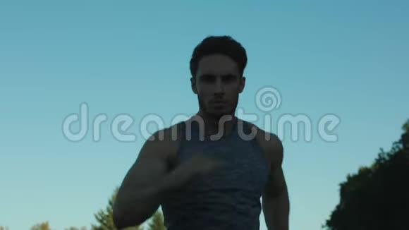男跑运动员在公园训练有氧运动运动男在蓝天上奔跑视频的预览图