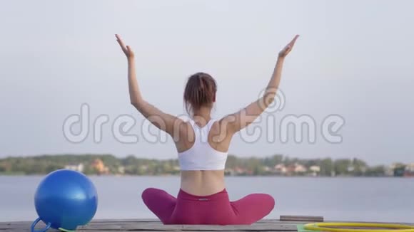 户外瑜伽年轻迷人的瑜伽女孩在莲花的位置冥想和享受精神平静的自然视频的预览图