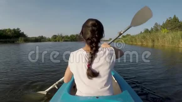 阳光明媚的一天女人在河上皮划艇视频的预览图