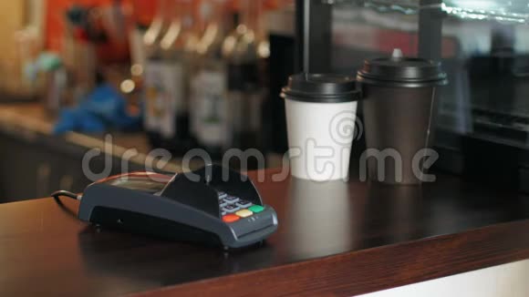 咖啡馆里穿着夹克的商人正在使用智能手机和终端来支付价格视频的预览图