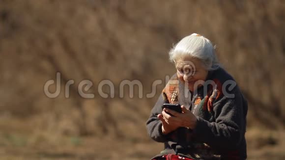 慢动作的幸福老妇人笑着看着智能手机的屏幕幸福的老年妇女肖像视频的预览图