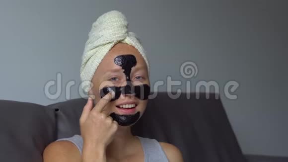 一个漂亮的年轻女人用手提式的照片戴上黑色的面罩视频的预览图